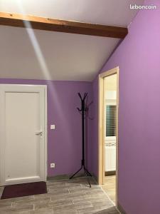 LʼAbergement-de-VareyUN PETIT COIN DE CAMPAGNE的一间有紫色墙壁的房间,里面装有三脚架