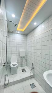 伊斯兰堡Hotel 11的白色瓷砖浴室设有卫生间和水槽