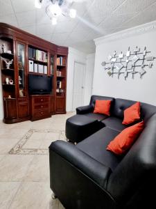布卡拉曼加Hermosa casa en Bucaramanga的客厅配有黑色沙发和电视