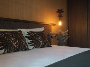 圣马洛圣马洛海滨美居酒店的一张带两个枕头和花瓶的床