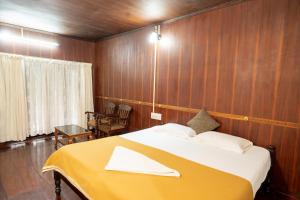 戈德亚姆Garggi Backwater Retreat的一间卧室配有一张带黄色毯子的大床