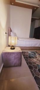 开罗Carpet Alaadein Pyramids view的一间卧室配有一张床和一张带台灯的桌子