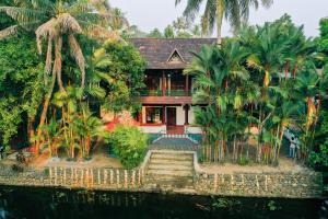 戈德亚姆Garggi Backwater Retreat的水边有棕榈树的房子