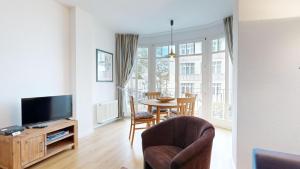 宾茨Haus Saxonia的客厅配有电视和桌椅