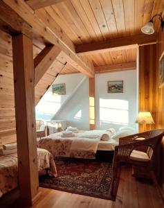 GoworówGospodarstwo Gościnne Jesionówka的一间带两张床的卧室,位于木天花板的房间