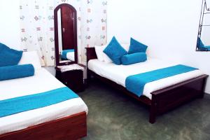 康提伯特利小憩民宿的客房配有两张带蓝色枕头的床。