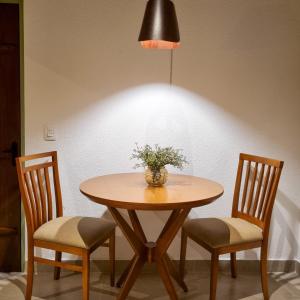 皮雷诺波利斯Pouso 22的一张桌子,上面有两把椅子和花瓶