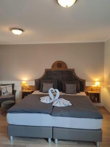 Emlichheim格鲁特恩格尔酒店的一间卧室配有一张带两个白色天鹅的床