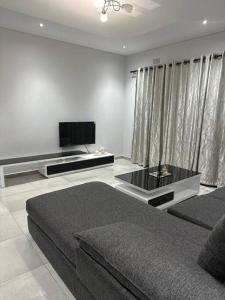 姆巴巴内Mountain Drive Apartments的客厅配有床和平面电视