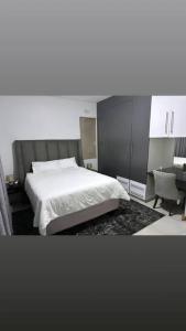 姆巴巴内Mountain Drive Apartments的一间卧室配有一张床、一张桌子和一把椅子
