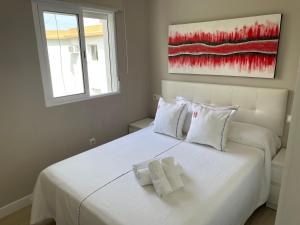 塞维利亚Ritual Sevilla, Fedriani的卧室配有白色的床和2条毛巾