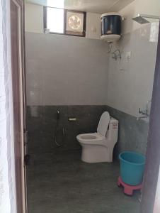 博瓦利Sadhna Holiday Home的一间带卫生间和墙上时钟的浴室