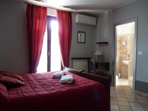 拉莫拉Agriturismo Viticcio的一间卧室配有一张带红色床单的床和一扇窗户。