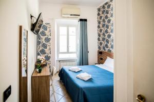 罗马德勒尔布酒店的一间卧室设有蓝色的床和窗户。