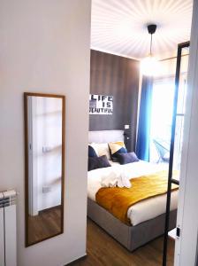 菲乌米奇诺Michelangelo Airport Suite Room的一间卧室配有一张床和镜子
