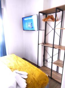 菲乌米奇诺Michelangelo Airport Suite Room的一间设有床铺和墙上电视的房间