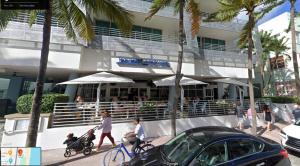 迈阿密海滩Boutique Suites 3 min walk to beach的一群人在大楼前行走和骑车