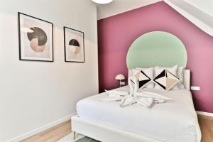 巴涅奥莱Appartement spacieux à 5 minutes de la capitale的卧室配有白色床和粉红色墙壁