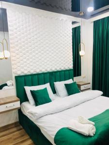 巴统Nana's House的一间卧室设有两张绿色大床。