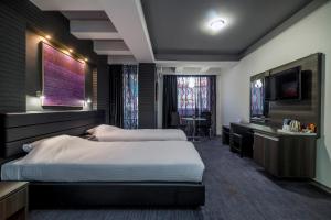 斯科普里Sienna Apartments的酒店客房设有两张床和一台平面电视。