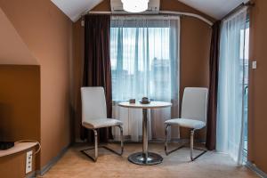 斯科普里Sienna Apartments的客房设有桌子、两把椅子和窗户。