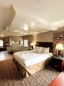 坎卢普斯Prestige Aberdeen Lodge Kamloops的一间带大床的大卧室和一间客厅