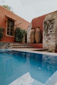 克雷塔罗Hotel Casa De Quino的两个大花瓶正坐在游泳池旁边