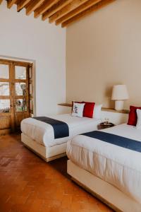 克雷塔罗Hotel Casa De Quino的一间卧室设有两张床和窗户。