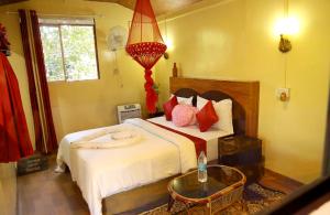 Anachalvattachalil villa的一间卧室配有一张带红色枕头的大床