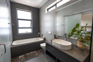 比勒陀利亚Luxurious Upmarket Apartment的带浴缸、卫生间和盥洗盆的浴室