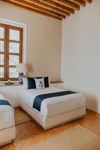 克雷塔罗Hotel Casa De Quino的卧室设有一张白色大床和一扇窗户。