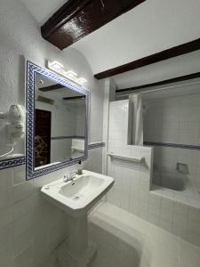 卡迪瓦Garden Suites Xativa的白色的浴室设有水槽和镜子