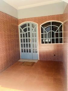 瓦加杜古Villa JFK2的一间设有两扇门和砖墙的房间