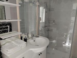 提乌克西亚维拉诺瓦公寓的白色的浴室设有水槽和淋浴。