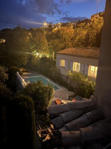格拉斯les petites terrasses的享有房子的景色,在晚上设有游泳池