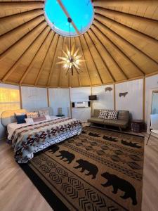 Valley CenterGlamping-Sky Dome Yurt-Tiny House-2 by Lavenders field的帐篷内一间卧室,配有一张床和一张沙发