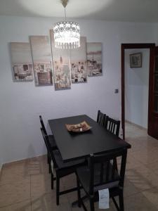 埃普拉特约布里加sweet house close to airport的黑色餐桌,配有椅子和吊灯