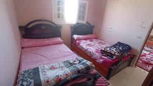 锡瓦Nubian Bayt Ward in Siwa的一间小卧室,配有两张床和镜子