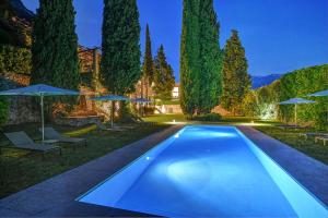 加尔尼亚诺5 Terrazze Exlusive Apartments的一个带遮阳伞的庭院内的游泳池