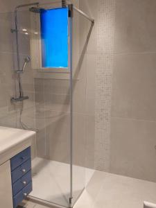 提乌克西亚维拉诺瓦公寓的浴室里设有玻璃门淋浴