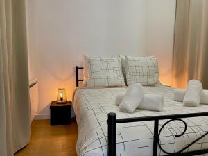 罗莫朗坦Les Logis d'Esmeralda-Des appartements au charme intemporel的一间卧室配有带白色床单和枕头的床。