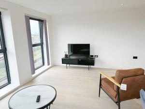 伦敦Luxury Modern Flat Near Center的客厅配有电视、沙发和桌子
