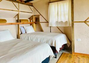危地马拉安地瓜Earth Lodge的客房设有两张床和窗户。