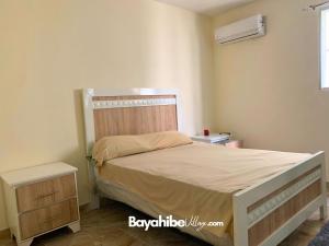 巴亚希贝El Sol ※ Bayahibe Village的一间卧室配有一张带木制床头板的床