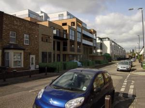 伦敦Luxury Modern Flat Near Center的停在城市街道上的蓝色汽车,有建筑