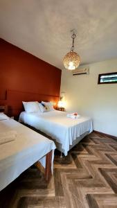 马劳Ayo Bistrô Pousada的酒店客房设有两张床和吊灯。