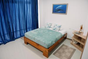 阿约拉港Modernas Habitaciones的一间卧室配有蓝色窗帘的床