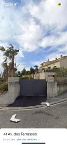 卡西斯Rêves de vie, appartement vue mer, grande piscine privée , spa privatif的一条有门的车道和一条有棕榈树的围栏