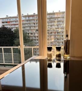 布鲁塞尔Logement Woluwé的窗户房间里一张带三根蜡烛的玻璃桌