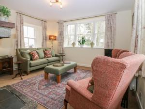 AlfordSteading Cottage - Craigievar Castle的客厅配有两把椅子和一张沙发